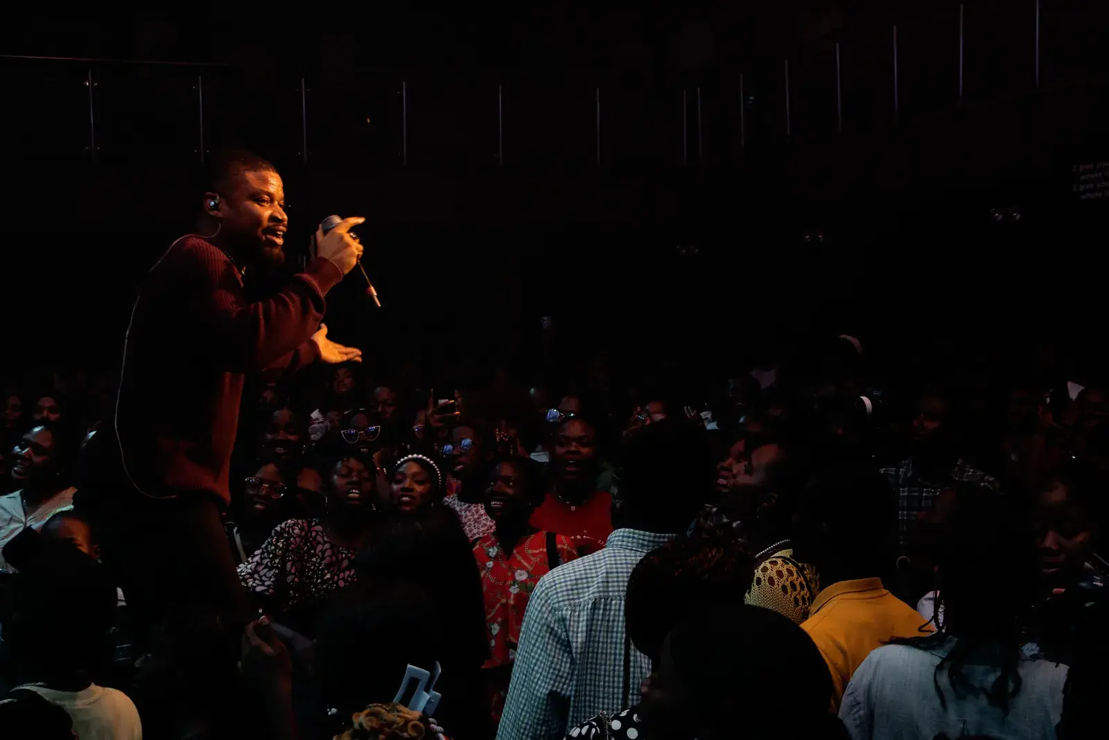 Wide photograph of Ko'rale performing to a packed room