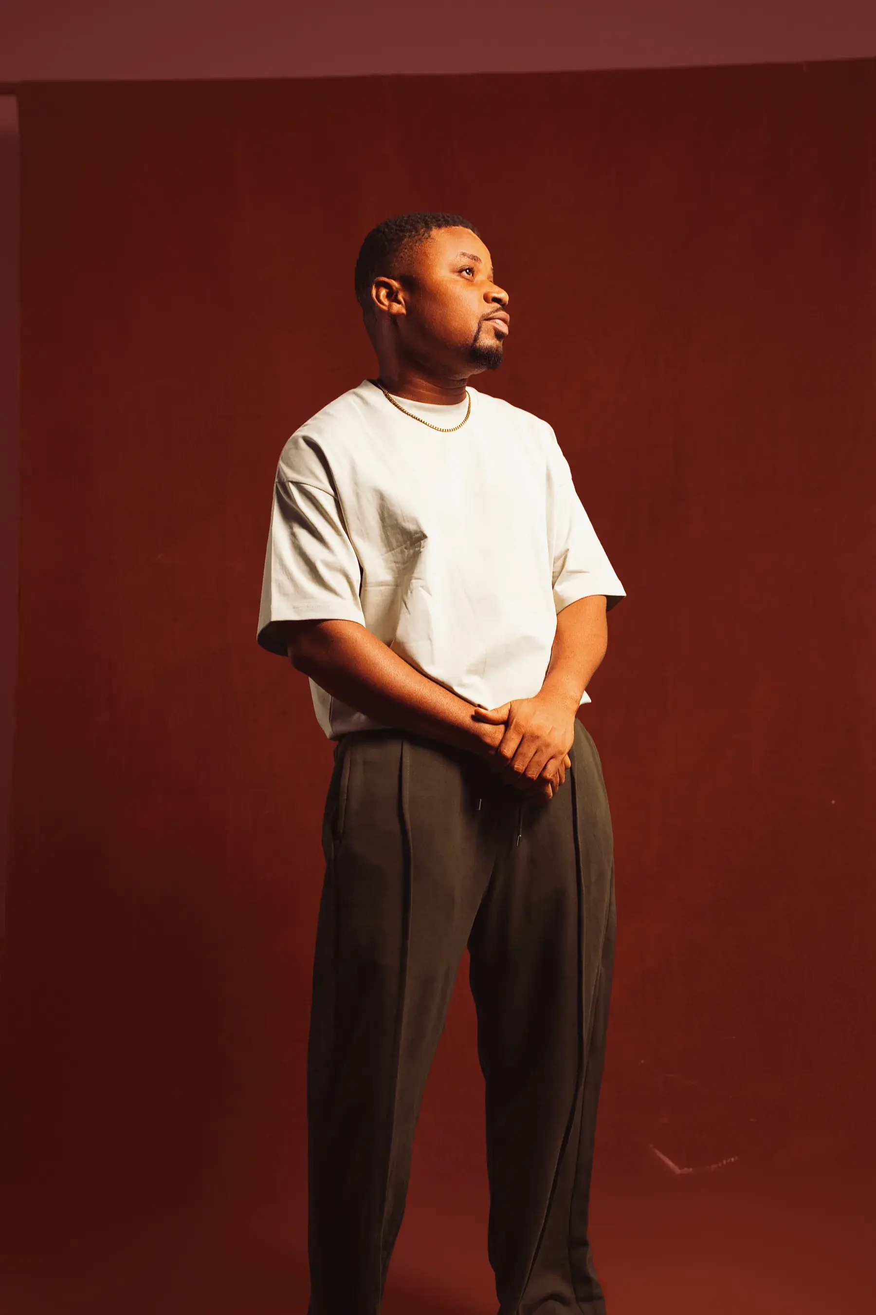 Ko'rale standing against a deep red studio backdrop